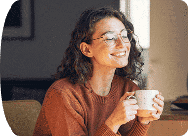 woman smiling while holding a cup